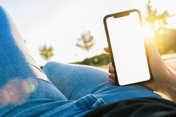 Mockup image of hands holding black mobile phone with blank desktop screen at summer