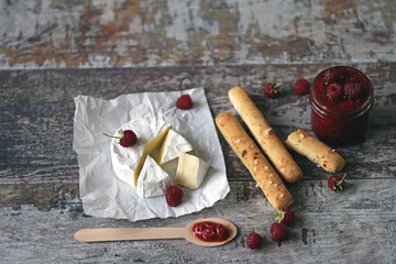 Camembert cheese with raspberry sauce and grissini sticks.