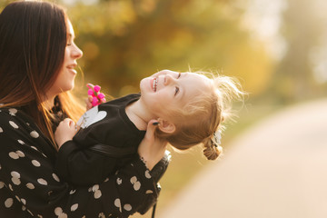 Mother and little daughter walking in autumn weather. Stylish little daughter and her beautiful mother. Happy childhood. Outdoors portrait of happy family. Have fun