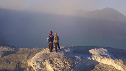 Aerial: People stay on the edge of crater  Kawah Ijen volcano, East Java, Indonesia
