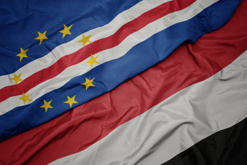 waving colorful flag of yemen and national flag of cape verde.