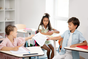 Boy sharing his homework with his best friend before the lesson