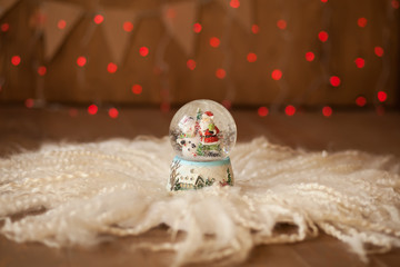 snow-covered Christmas ball on the background of red garlands