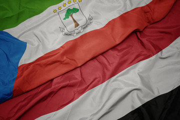 waving colorful flag of yemen and national flag of equatorial guinea.