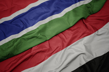 waving colorful flag of yemen and national flag of gambia.