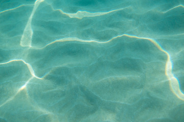 Underwater. Sun glare at the bottom of the sea. Waves underwater and rays of sunlight shining...