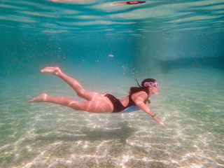 Girl snorkeling in a green swimming pool underwater photography