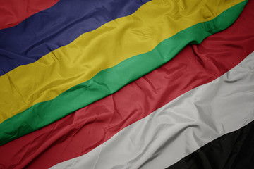 waving colorful flag of yemen and national flag of mauritius.