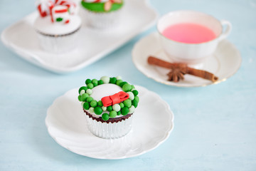 Homemade Christmas cupcake with traditional red green decorative symbols elements