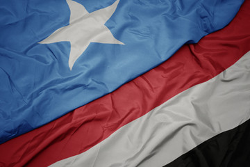 waving colorful flag of yemen and national flag of somalia.
