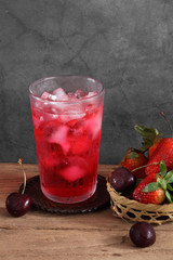 Red cocktail and strawberry and cherry in wooden basket with a blank space for a text, Fruit in kitchen background