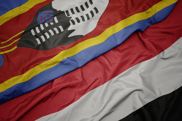waving colorful flag of yemen and national flag of swaziland.