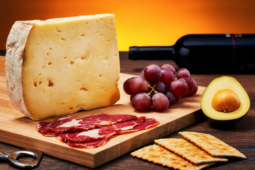 Aged cheese on wooden table with wooden cutting board