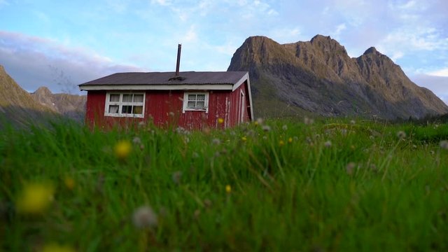 A red small house in the mountains. Jib camera movement . From &Oslash;rsta, Norway.