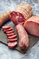 Assortment of delicious deli meats on wooden board