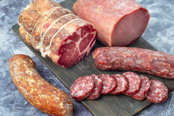Assortment of delicious deli meats on wooden board