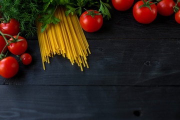 Dry pasta and vegetables on a wooden table top view.