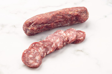 Salami smoked sausage, on white stone.