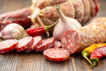 Sliced salami on wooden board.