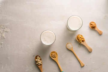 Glasses of milk with nuts: Macadamia, almond, soy, rice, lotus. Top view.