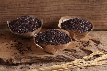 riceberry rice in wooden cup on wooden tray, riceberry rice in kitchen background