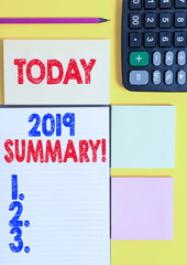 Writing note showing 2019 Summary. Business concept for summarizing past year events main actions or good shows Colored empty papers with copy space on the yellow background table