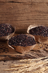 riceberry rice in wooden cup on wooden tray, riceberry rice in kitchen background