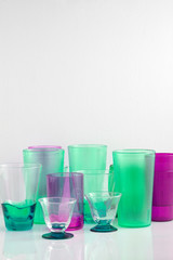 Group of various color glass on white table with a blank space for a text, glass on white background