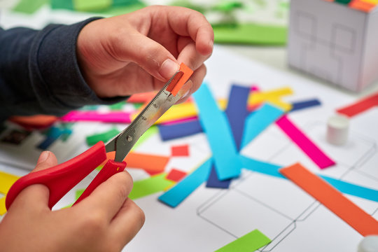 A Childrens Craft Session In Front Of A Teacher Cutting Up Colourful Paper With Scissors