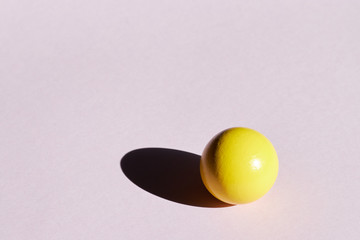 Yellow ball on a light background with hard shadows. abstract background for design. copy space. geometry