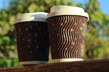 Two coffees to go on the wooden balcony. Lifestyle concept.