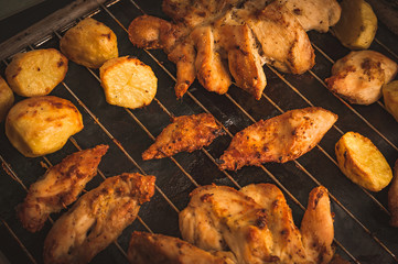 Roasted Chicken Slices and Potatoes on Stainless Steel Cooking Grid. Grilled Chicken Breast with Slices Made for Marinade to Penetrate the Meat Better, and Ensure Chicken Cooked Evenly.