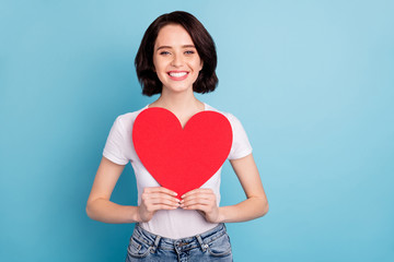 Portrait of her she nice attractive lovable lovely glad sweet tender cheerful girl holding in hands big heart symbol card isolated on bright vivid shine vibrant blue turquoise color background