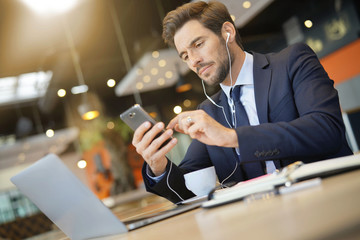 Businessman talking on phone at airport waiting room
