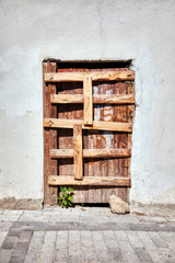 Wooden door of a shanty house barred shut with planks