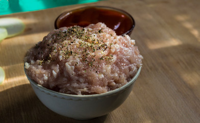 minced meat in the plate, red sauce in a plate on a wooden board