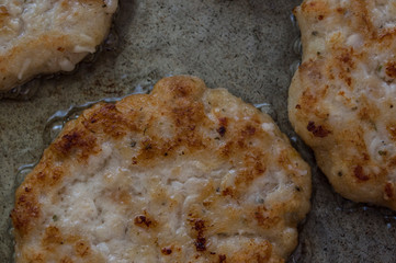 closeup of meat cutlets being cooked in a hot pan