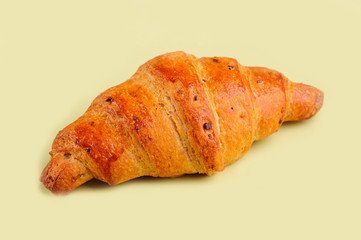 Croissant on yellow board.