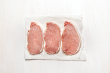 Pieces of pork loin. Raw meat on parchment.On white background. BBQ