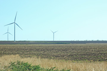 Wind turbines energy converters on the nature background.