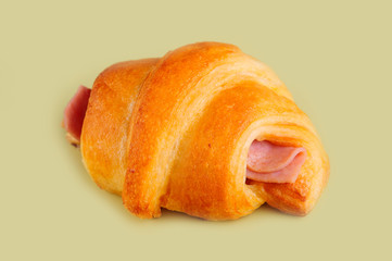 Croissant hot dog on yellow board.