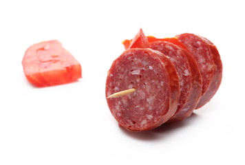 Fermented semi-dry, smoked sausage salami with tomato slice, isolated on white background