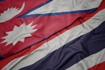 waving colorful flag of thailand and national flag of nepal.