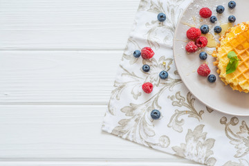 breakfast belgian waffles with blueberries and raspberries on a white background