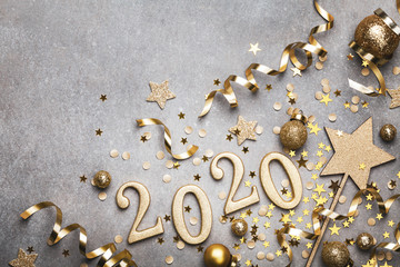 Holiday background with golden Christmas decorations and New year 2020 numbers and confetti stars...