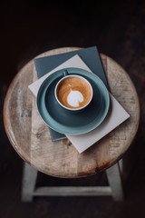 Cup of coffee and books on a wooden chair