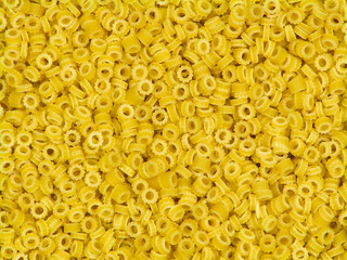 Uncooked yellow italian pasta anelli close-up background top view