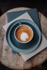 Cup of coffee and books on a wooden chair