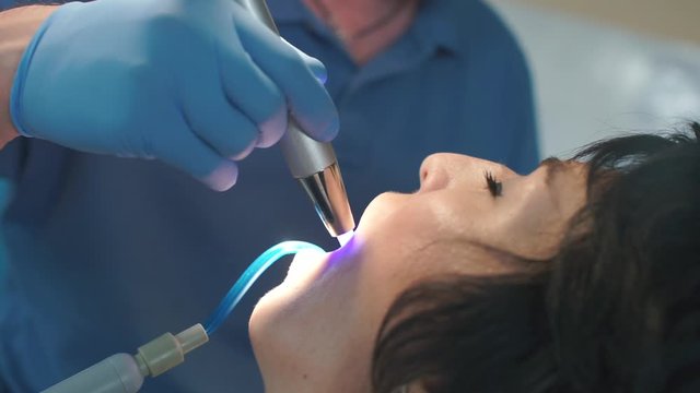 the dentist uses special light to treat teeth