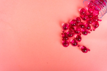 Pink vitamin serum capsule on pink background.Hair loss treatment